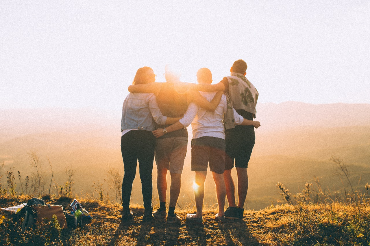 photo of people hugging and looking toward the sun